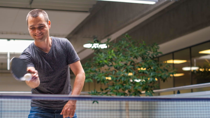 Guy playing table tennis at SANOVO TECHNOLOGY GROUP