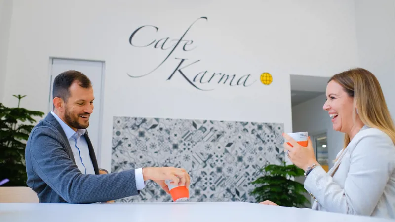 Two people sitting and talking over coffee in Café Karma at SANOVO TECHNOLOGY GROUP headquarters