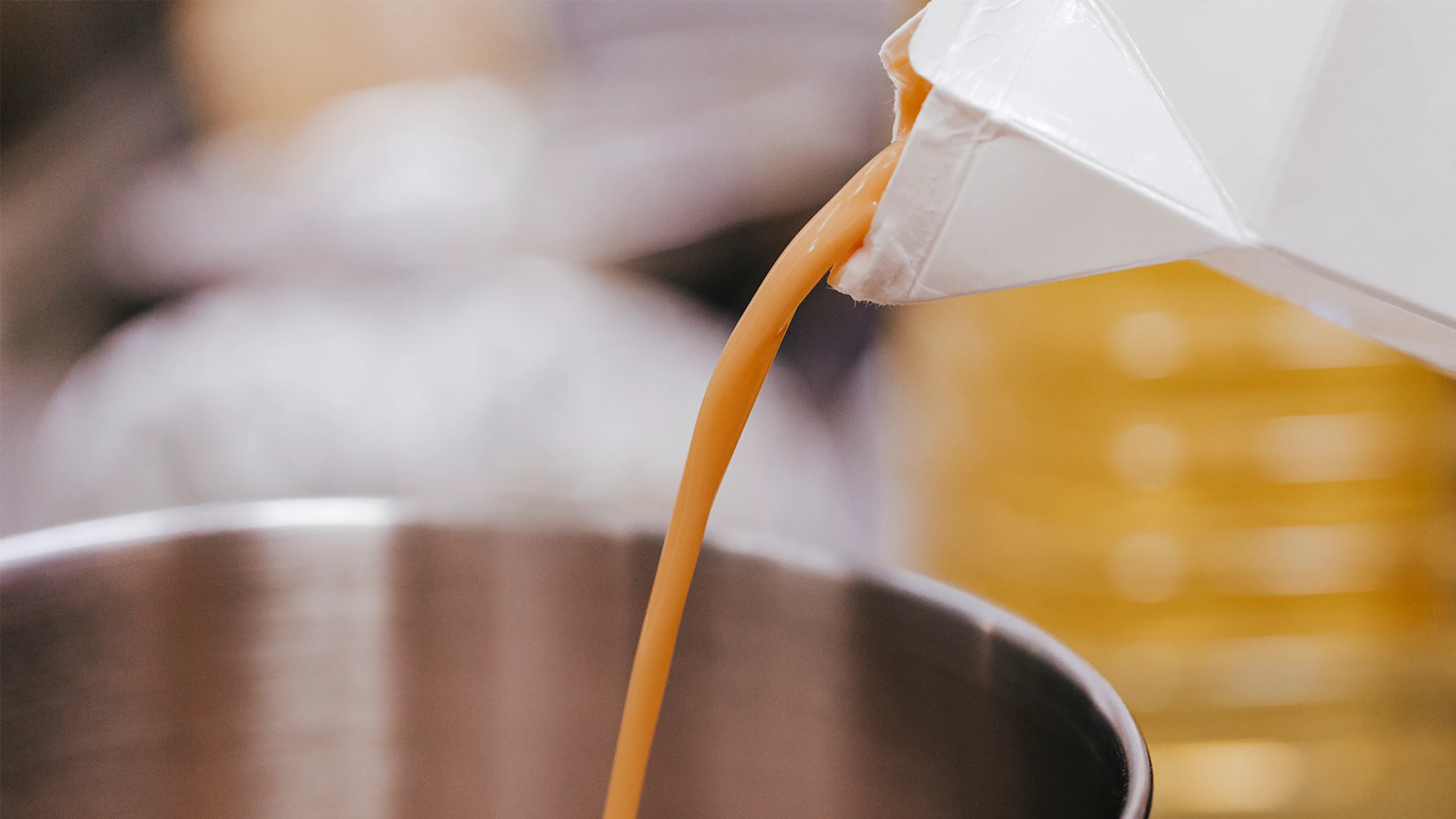 Liquid egg being poured into a container during processing.