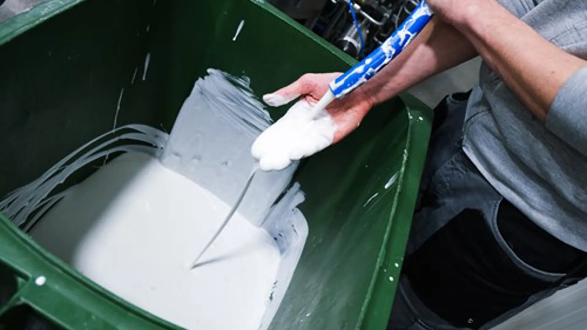 Operator handling a viscous white product during testing of SANOVO WAVE System.