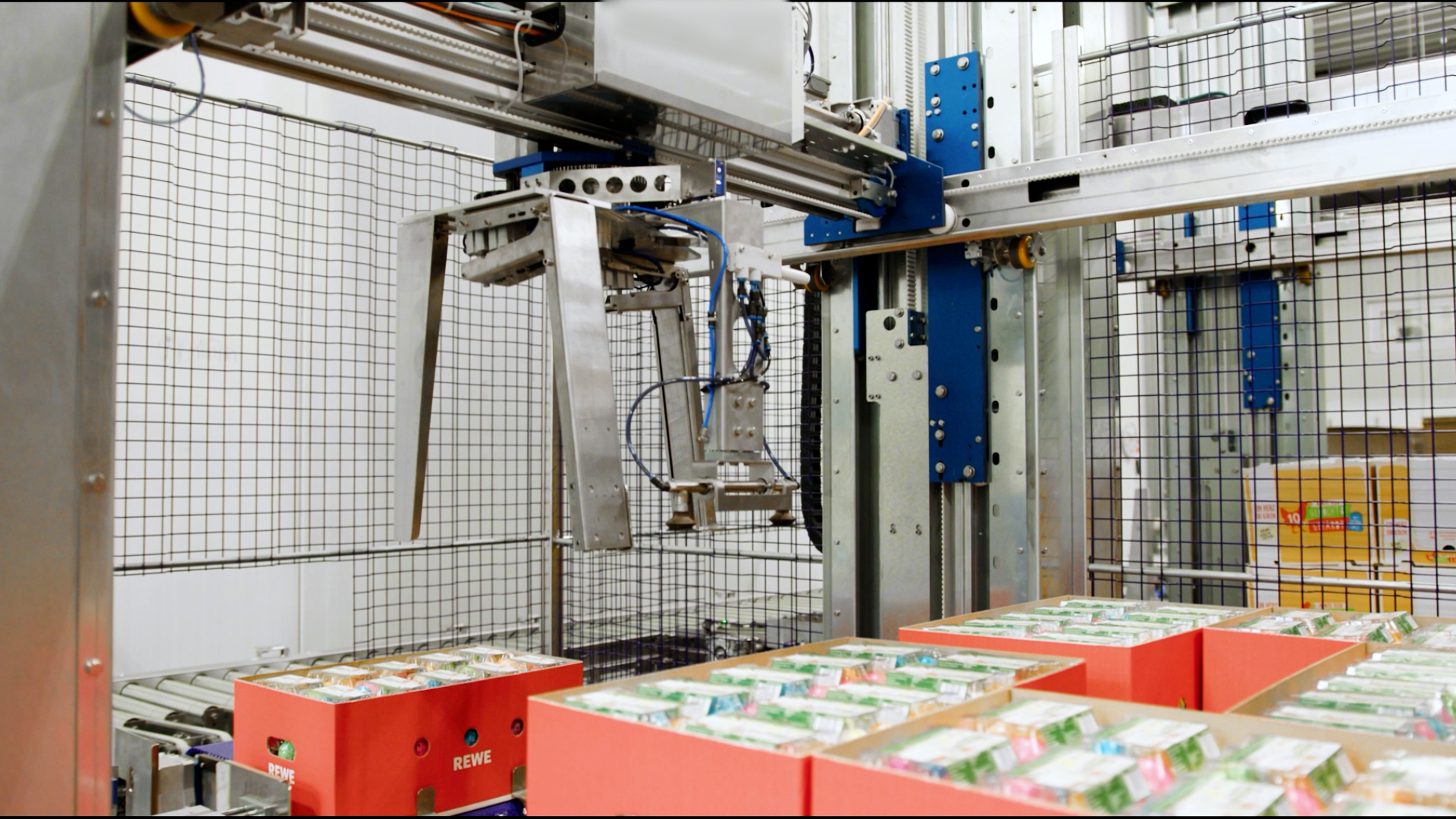 Close-up of SANOVO Case Palletizer 300 robotic gripper stacking cartons in automated egg packaging process.