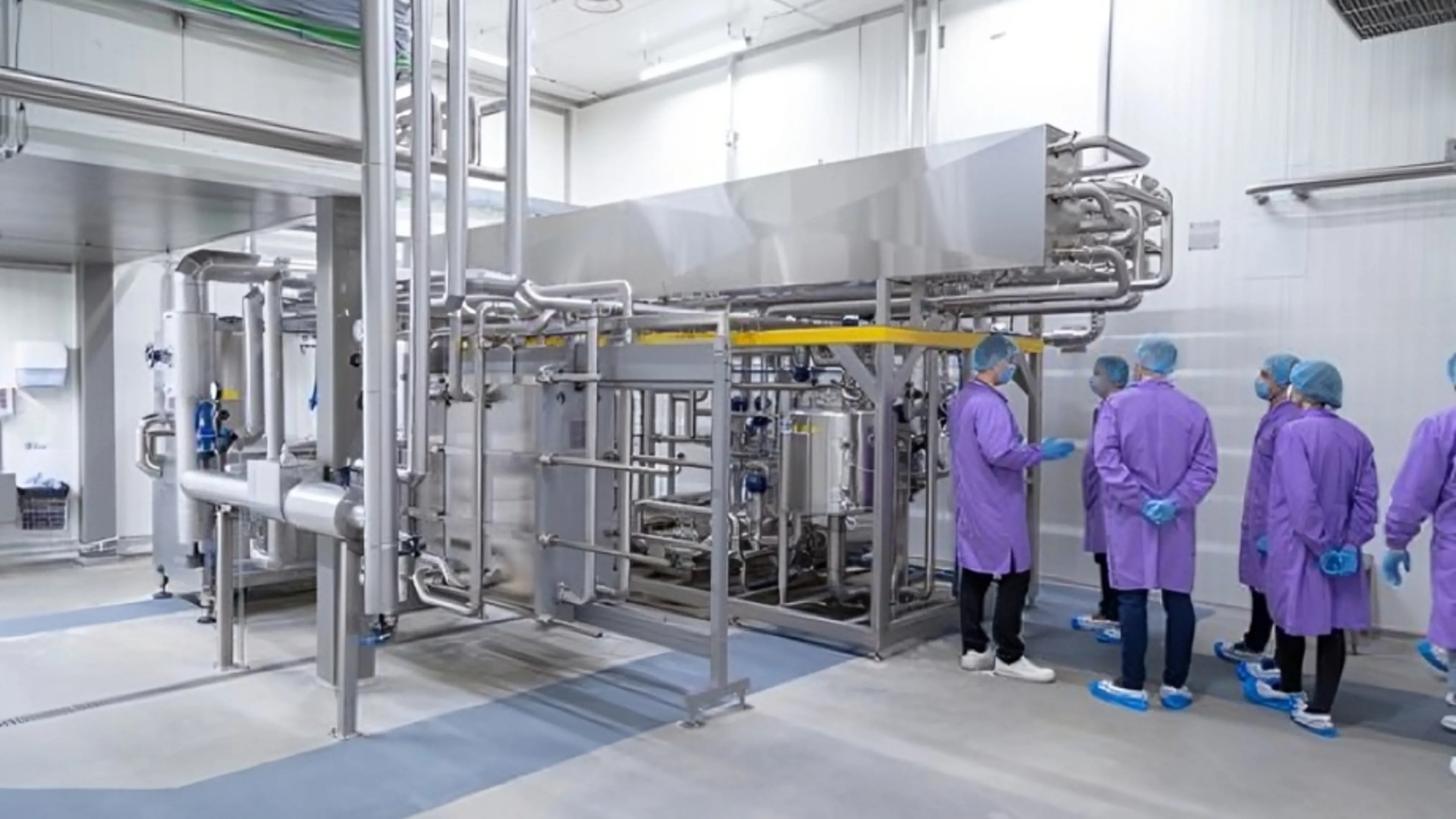 Operators inspecting SANOVO pasteurization and CIP system at Groward Group facility.