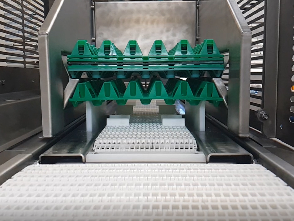 Front of an OptiLoader Plus 6C egg loading machine transferring eggs from trays to a grading line.