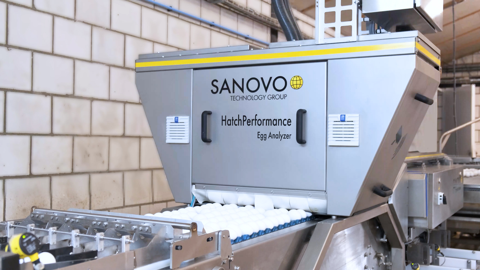 Front view of the SANOVO HatchPerformance Egg Analyzer inspecting eggs on a conveyor belt.
