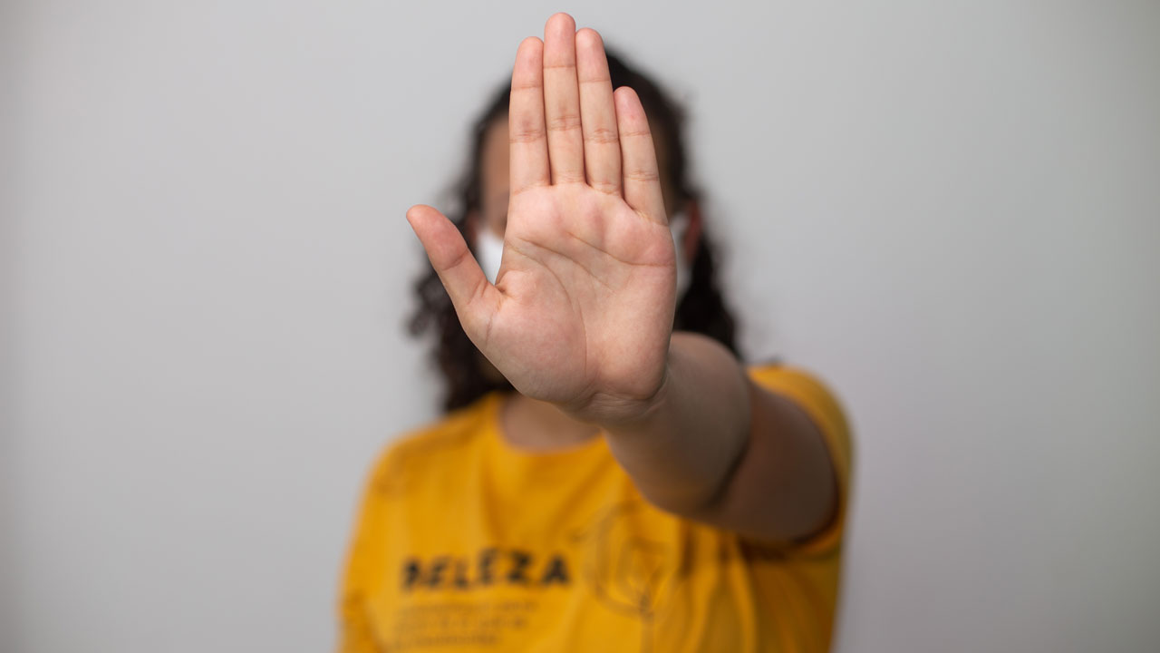 Person raising hand forward in a stop gesture