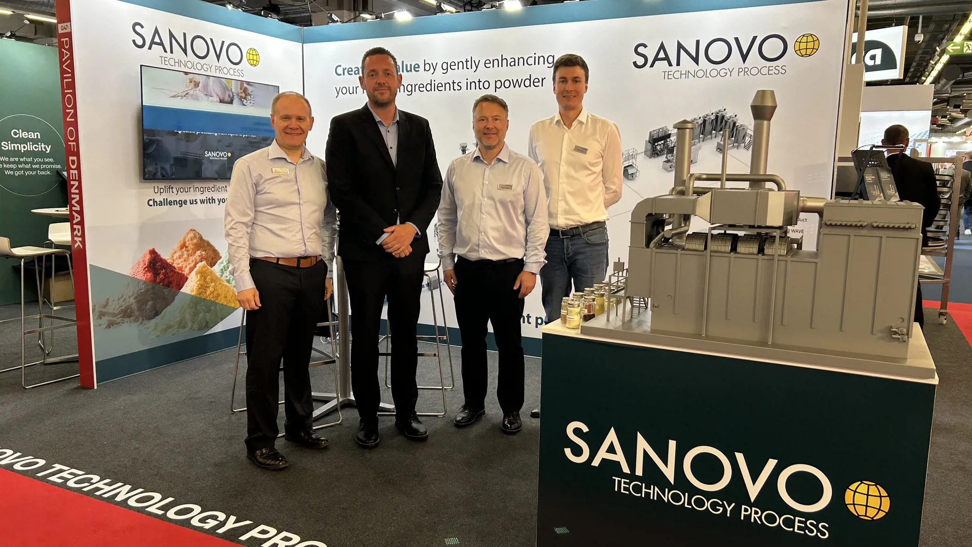 SANOVO TECHNOLOGY PROCESS team at a trade show booth presenting spray drying and powder processing solutions.