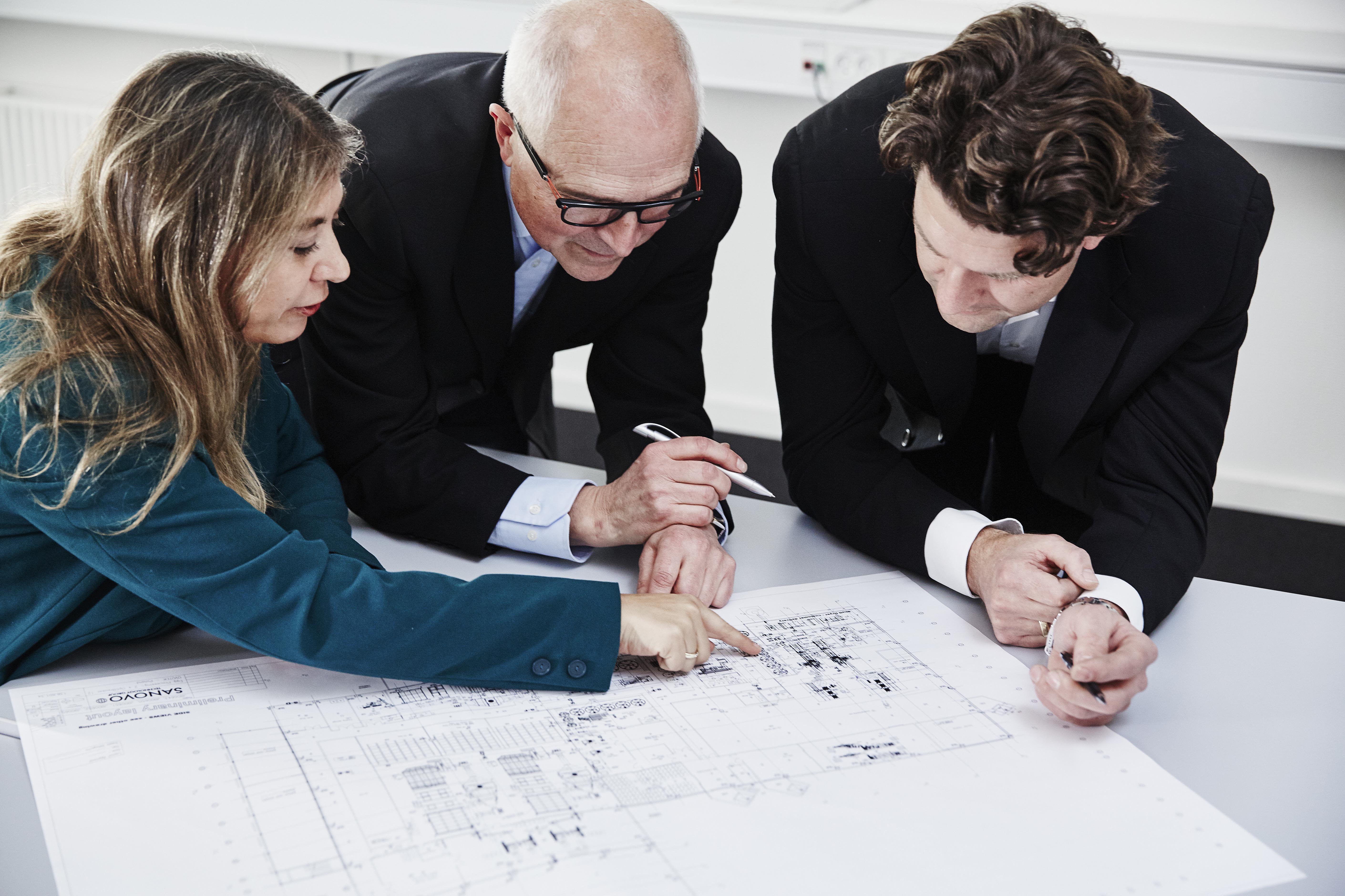 Team reviewing technical drawings during a pre-sale engineering assessment.