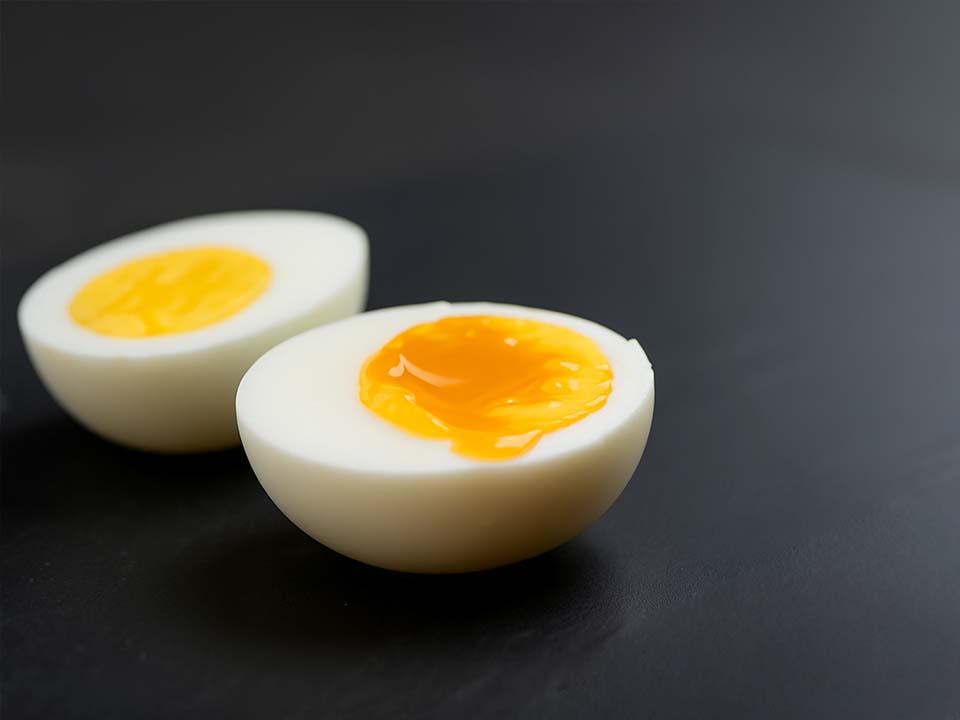 Close up of a soft-boiled egg and a hard-boiled egg.