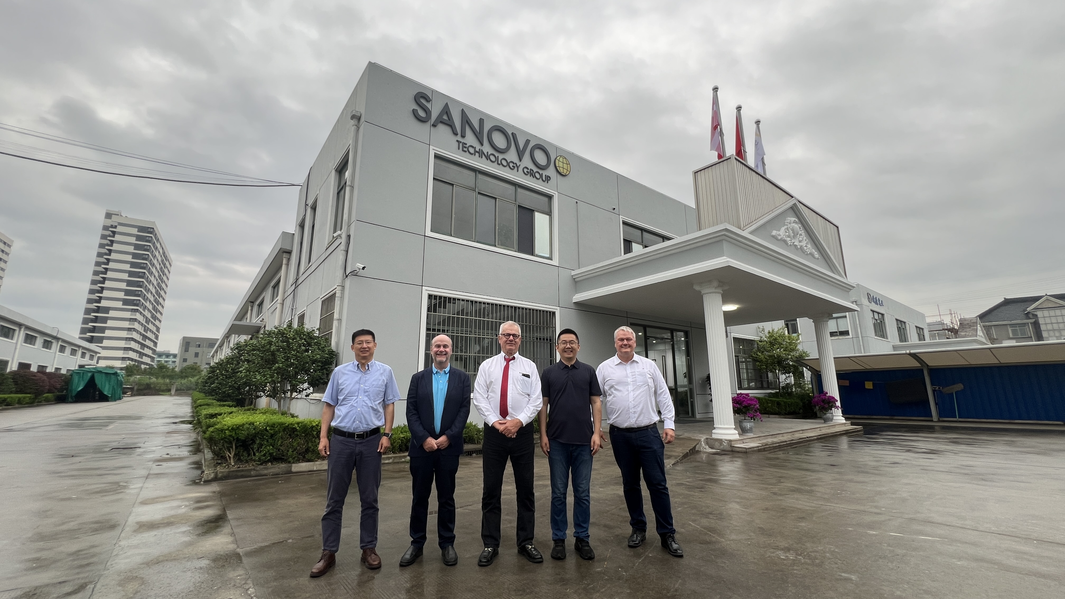 Staff standing in front of SANOVO TECHNOLOGY CHINA building. 