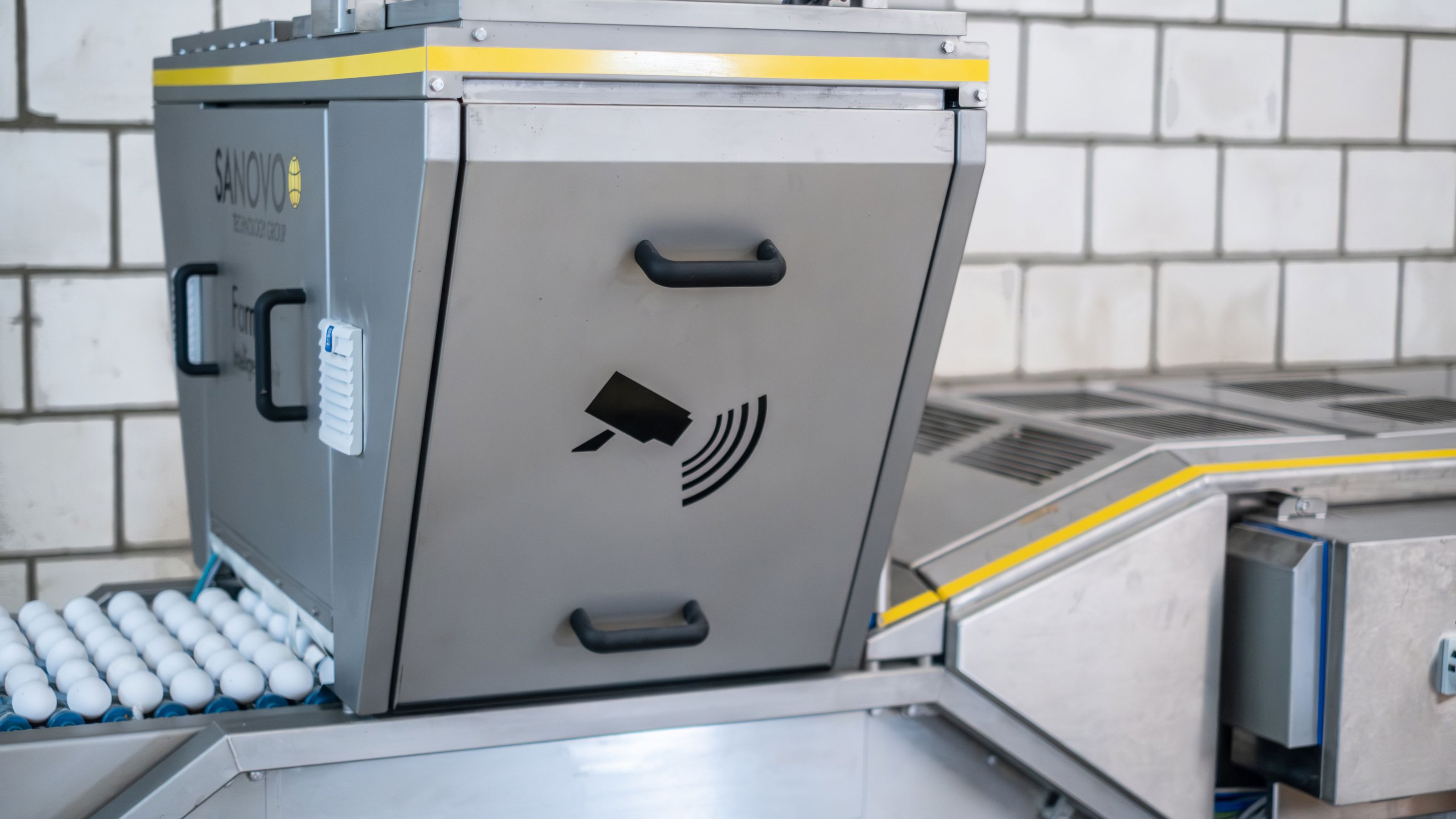 Close-up of the SANOVO Farm Intelligence Unit using AI-powered cameras to inspect eggs on a conveyor