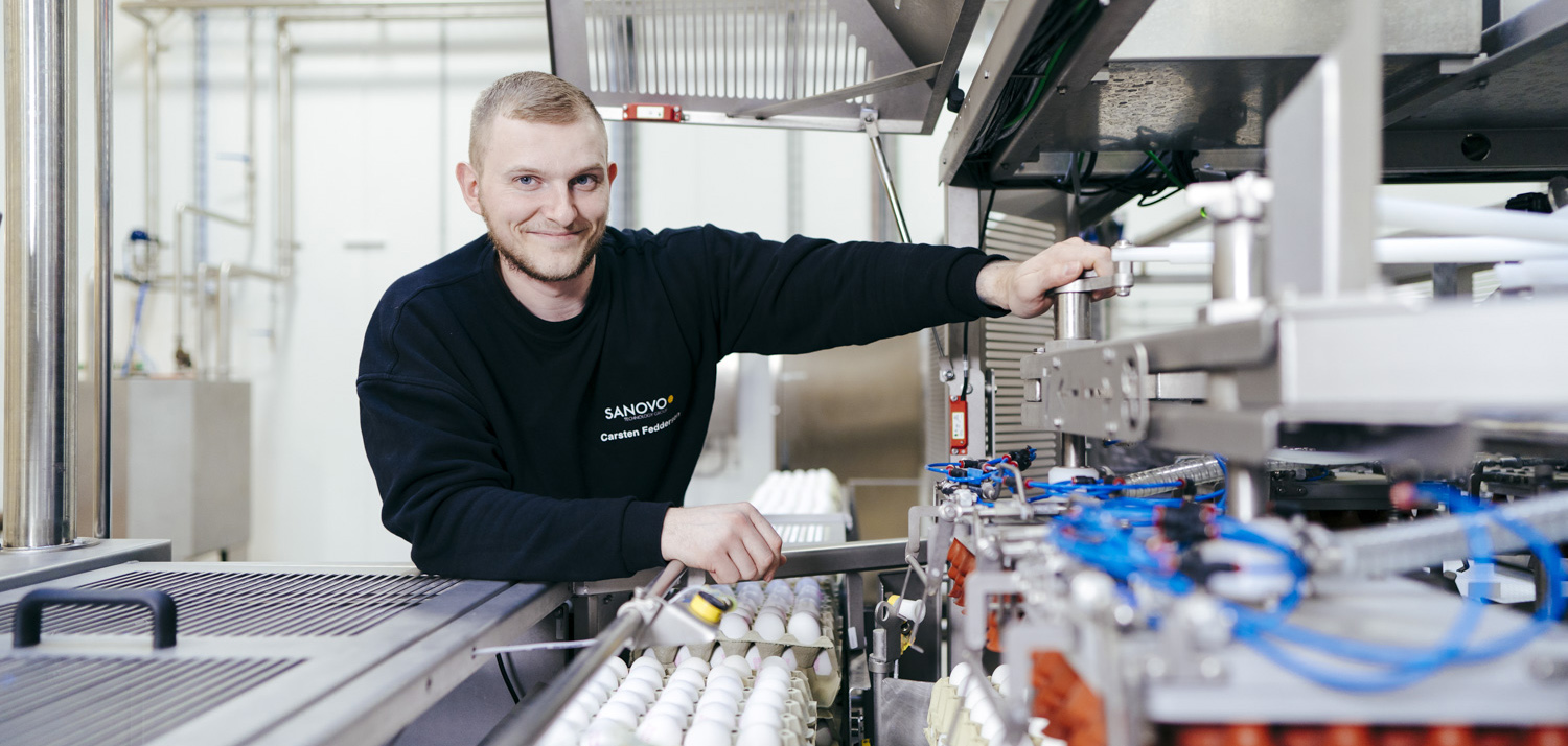 Service technician standing next to SANOVO equipment.