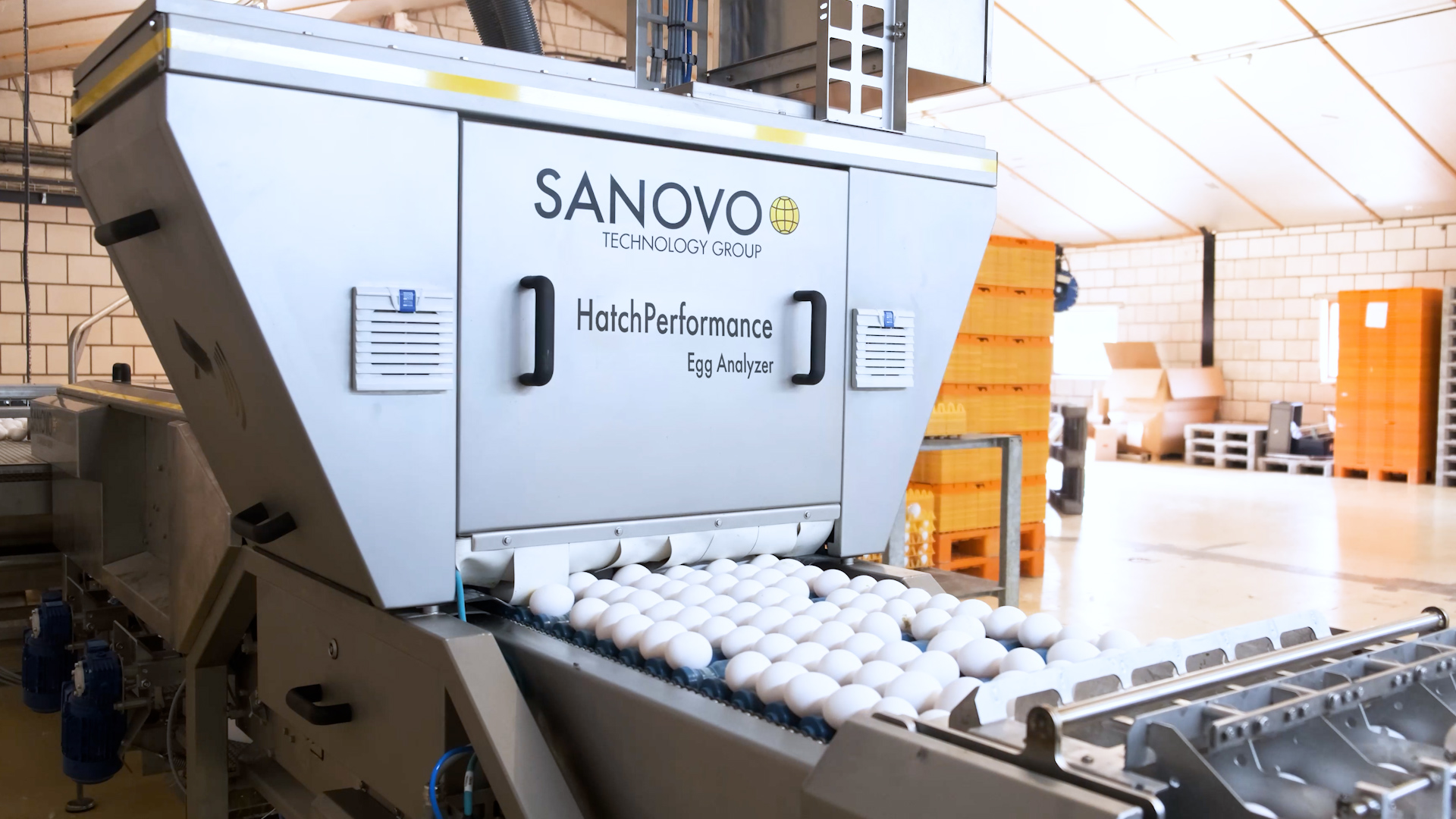Side view of the SANOVO HatchPerformance Egg Analyzer inspecting eggs on a conveyor belt.