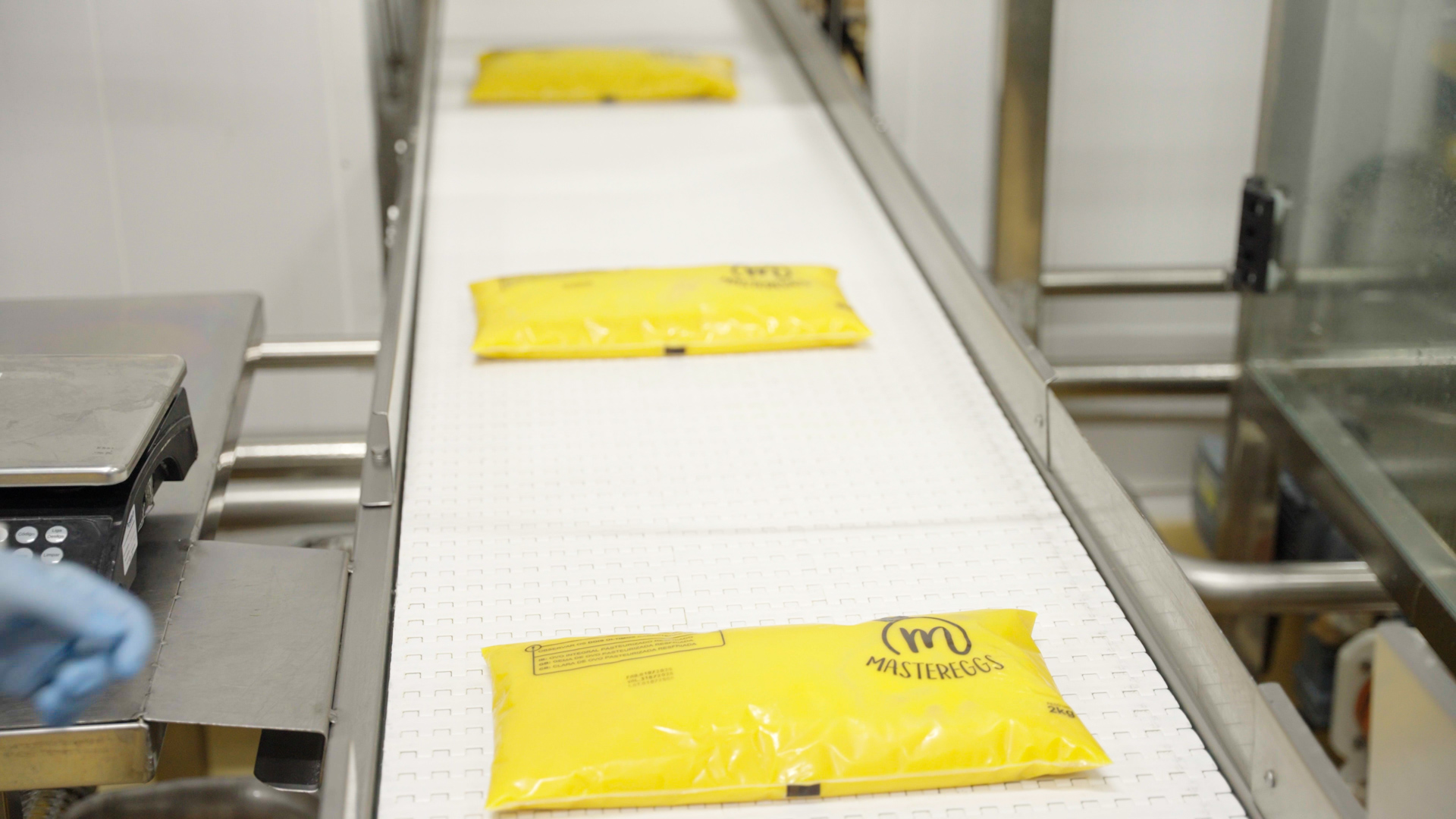 Filled liquid egg bags transported on a conveyor in the Master Eggs processing facility.