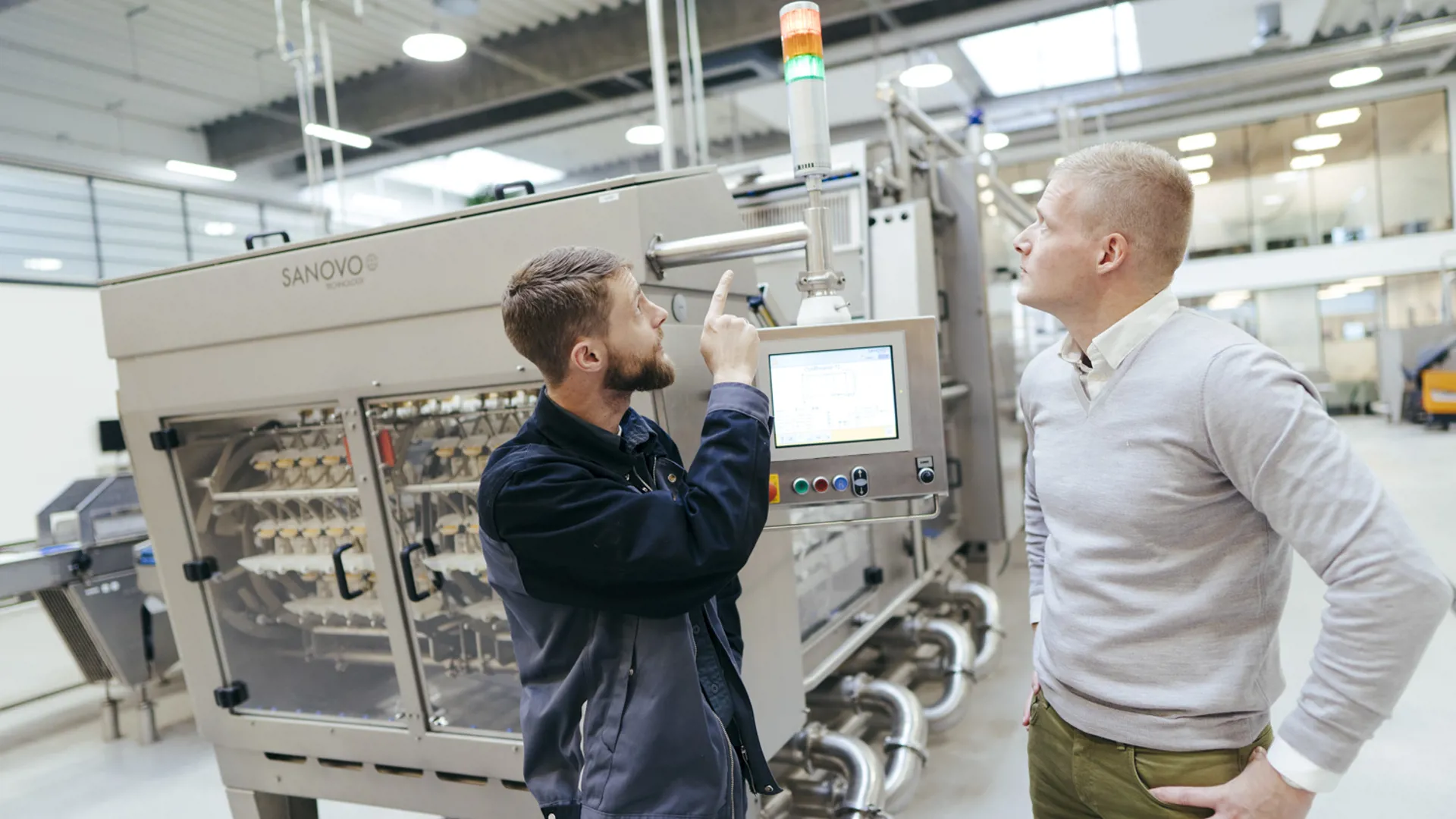 Two men inspecting the SANOVO OptiBreaker in the experience center