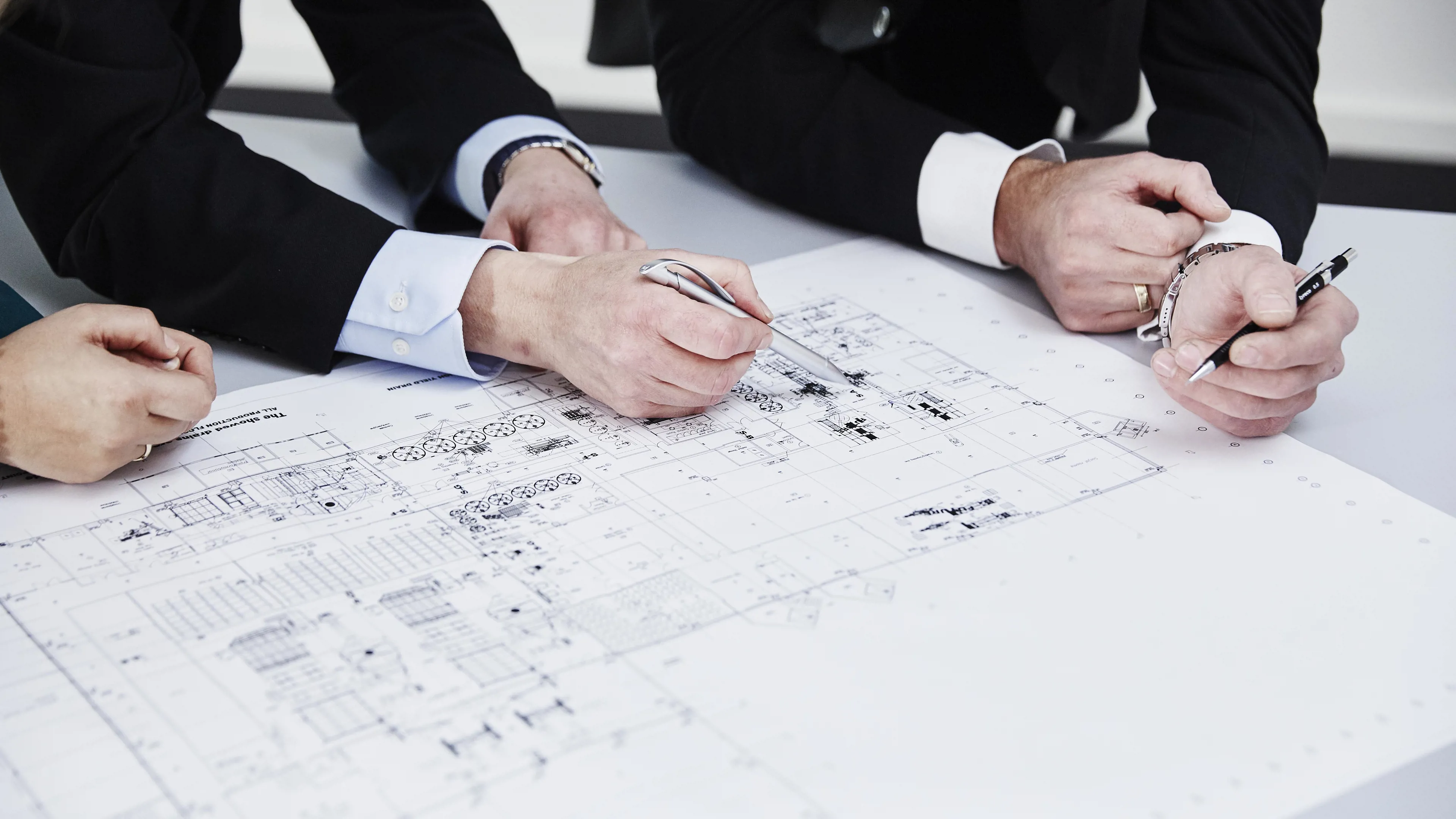 Team reviewing technical blueprints during project planning and engineering design at SANOVO TECHNOLOGY GROUP