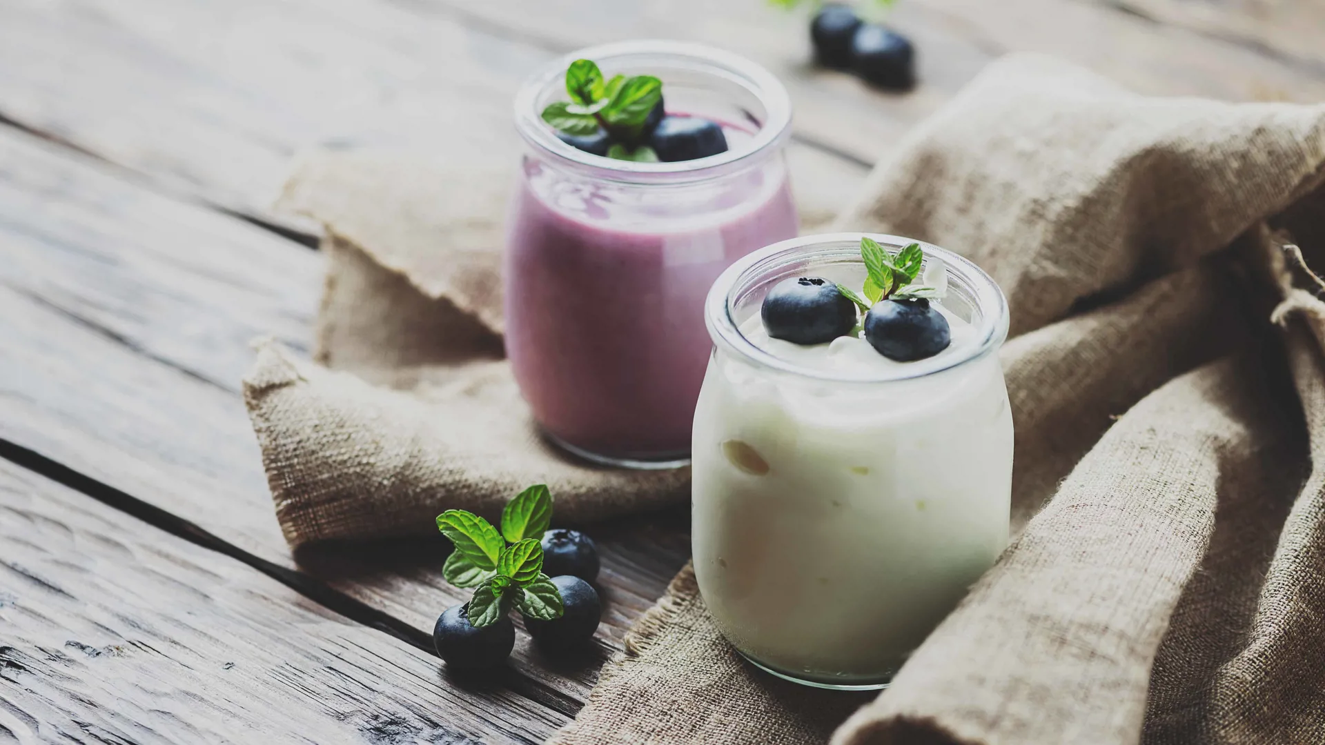Yogurt in glass jars with blueberries and mint, dairy product