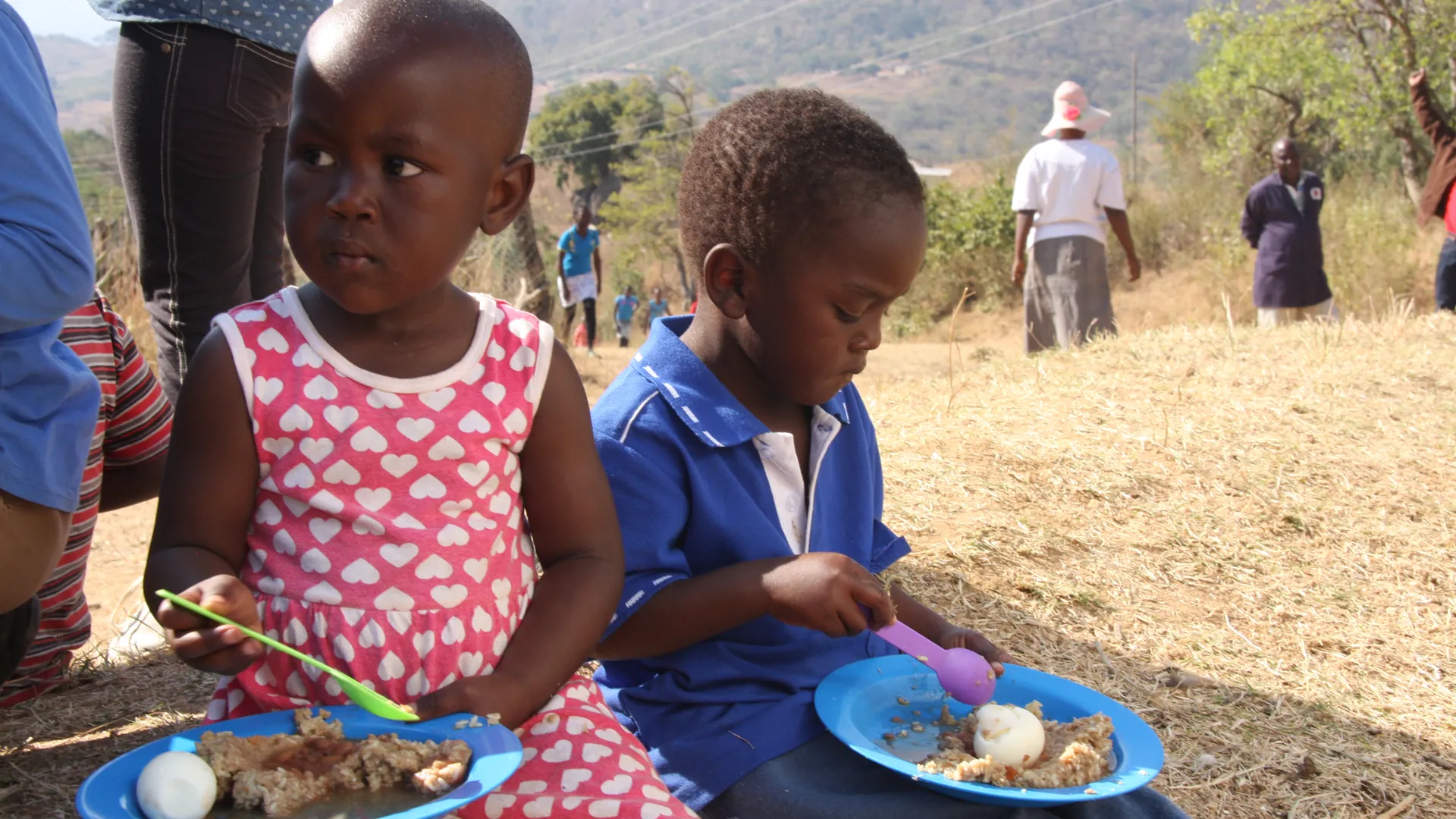 Children enjoying meals with eggs at community project.