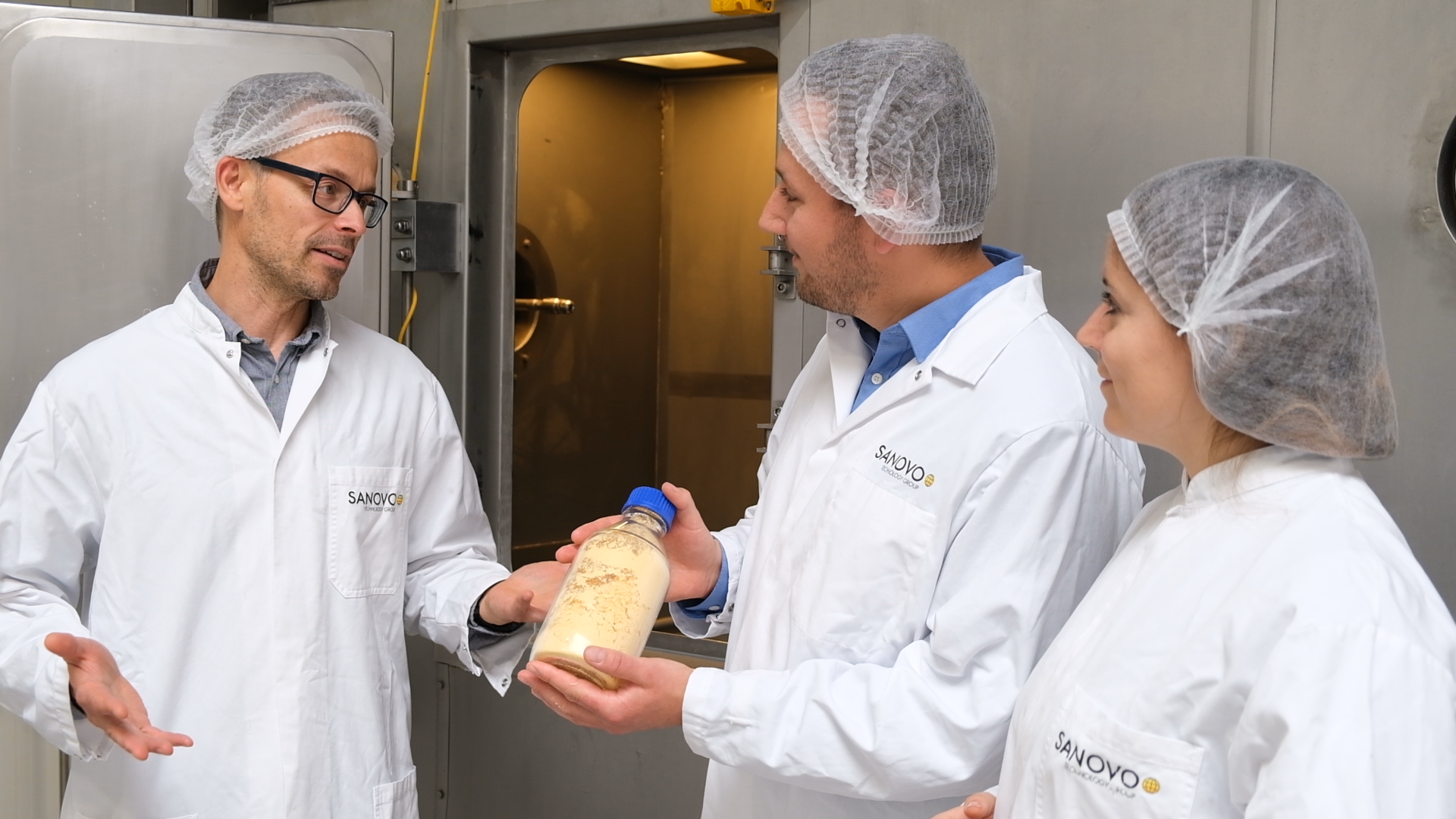 Operators collaborating during powder evaluation in a powder production environment.