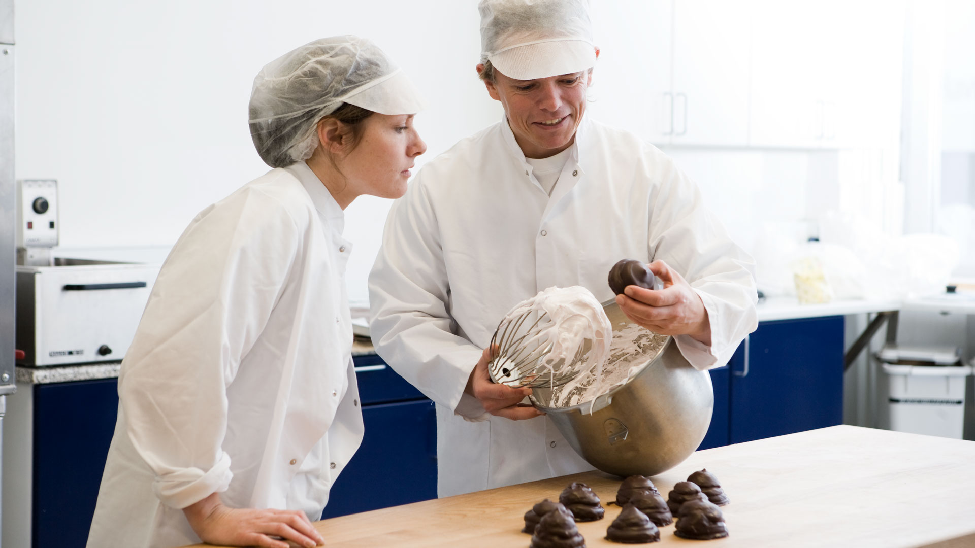 SANOVO technologists whipping egg white during enzyme performance testing in processing trials.