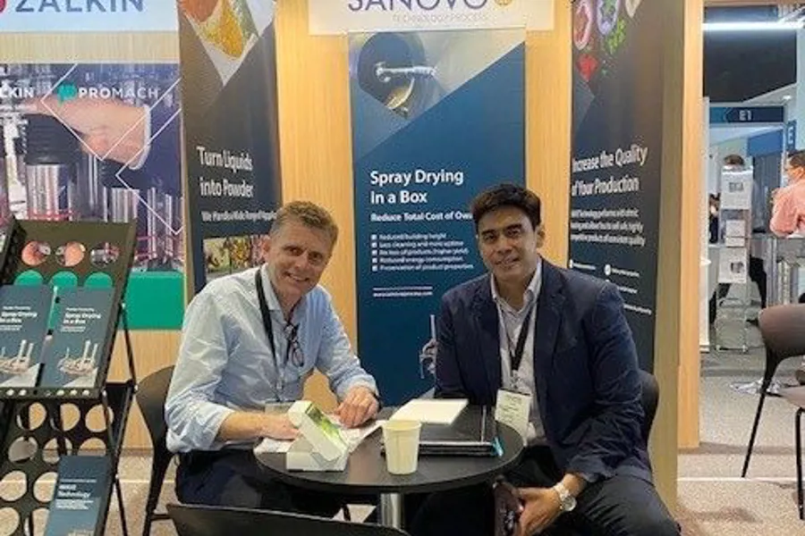 SANOVO TECHNOLOGY PROCESS exhibition booth with team members discussing spray drying solutions at an industry trade show.