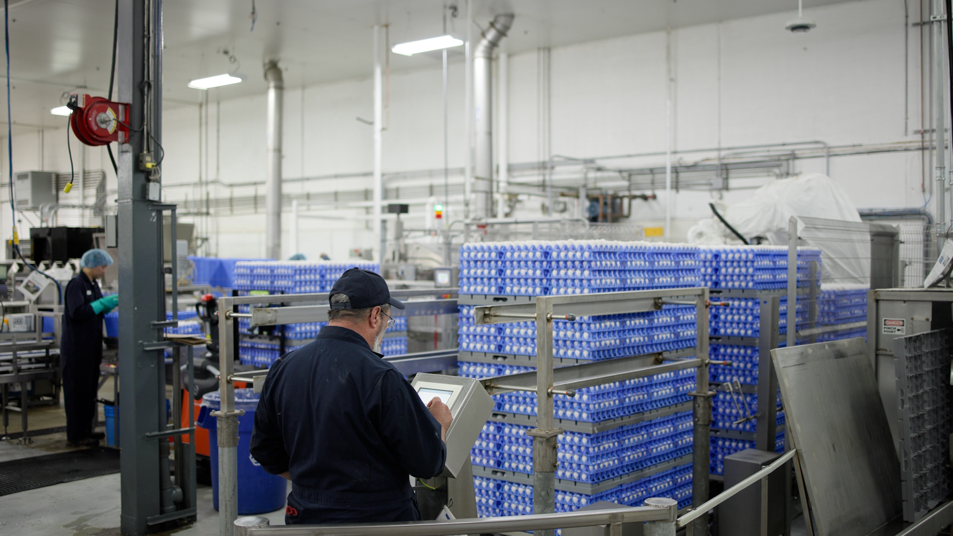 Operator inspecting egg trays in a SANOVO customer’s egg processing facility.