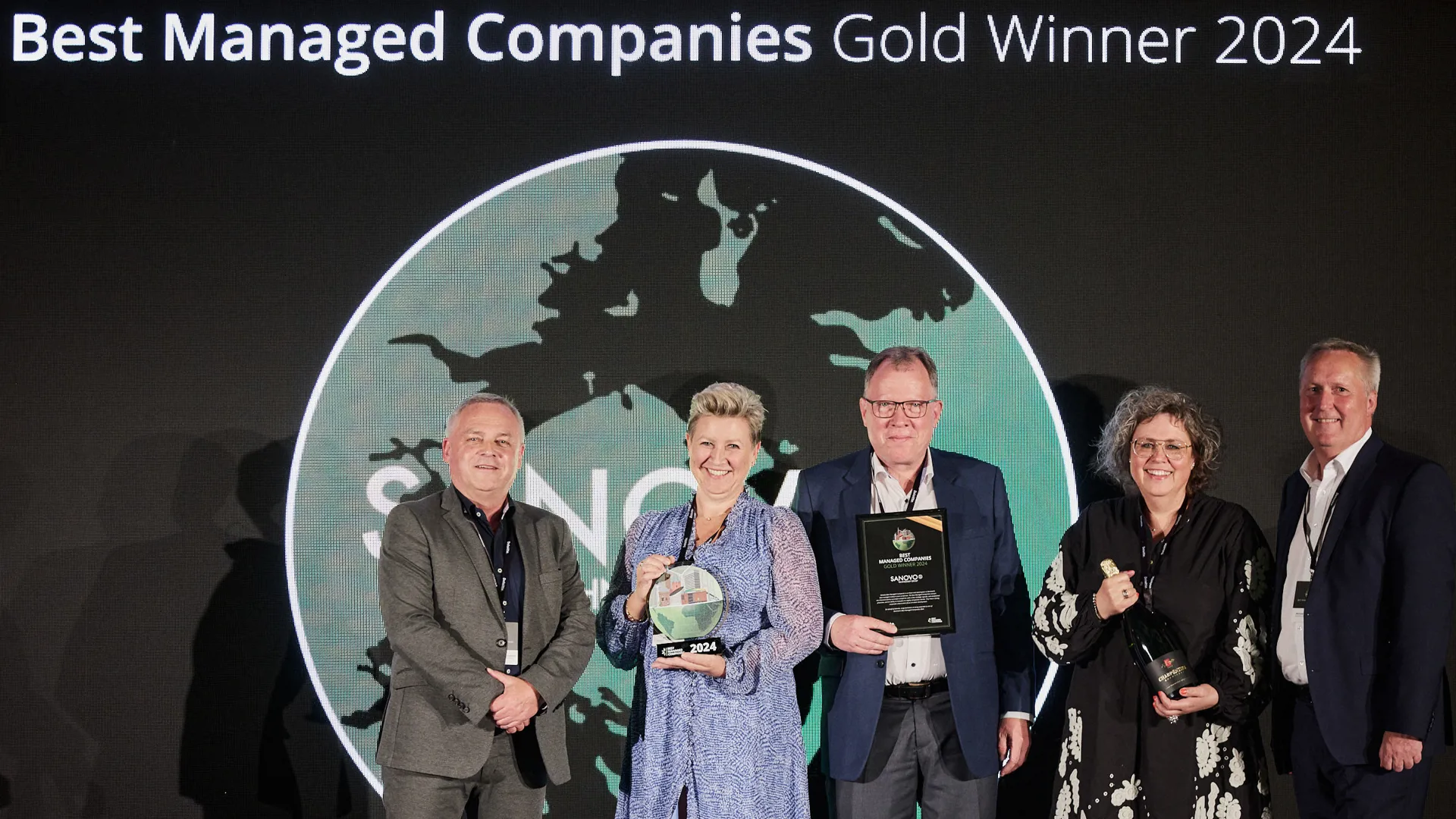 SANOVO management holding the Best Managed Company Award 2024 statuettes.